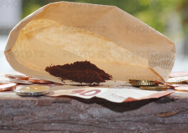 Ground coffee in a filter bag with coins and a ten euro note in front of it, North Rhine-Westphalia, Germany