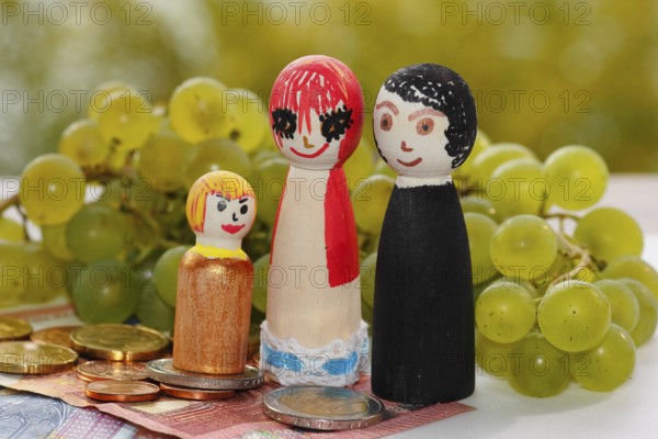 Wooden cone family with grapes and coins and banknotes, North Rhine-Westphalia, Germany