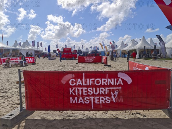 California kitesurfing Masters 2025, Kite Village tents with kite equipment for sale, marketplace, trying out, kitesurfing on the North Sea beach, blue sky, sun, summer, Volkswagen, camper vans, Ording, Sankt Peter-Ording, Schleswig-Holstein, Germany