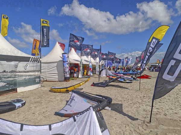 California kitesurfing Masters 2025, Kite Village tents with kite equipment for sale, marketplace, try out, kitesurfing on the North Sea beach, blue sky, sun, summer, Ording, Sankt Peter-Ording, Schleswig-Holstein, Germany