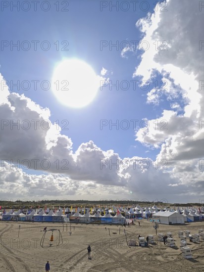 California kitesurfing Masters 2025, tents of the Kite Village with kite equipment for sale, marketplace, try out, kitesurfing on the North Sea beach, blue sky, sun, summer, backlight, Ording, Sankt Peter-Ording, Schleswig-Holstein, Germany