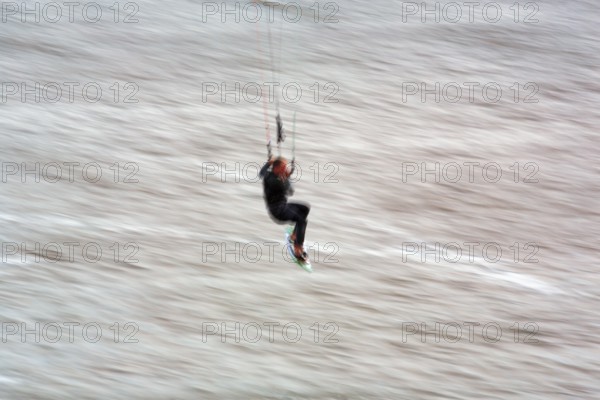 Kitesurfer jumping in the surf, wiping effect, long exposure, Sankt Peter-Ording, Eiderstedt peninsula, Wadden Sea National Park, North Frisia, Schleswig-Holstein, Germany