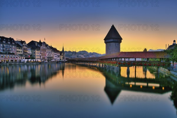 Chapel bridge with water tower reflected in the river Reuss, Lucerne old town at dawn, Canton Lucerne, Switzerland