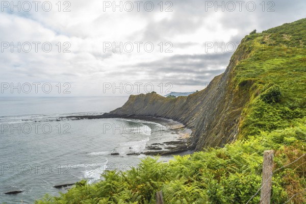 Breathtaking view of the flysch cliffs meeting the ocean waves at sakoneta beach in zumaia, a geological wonder in the basque country