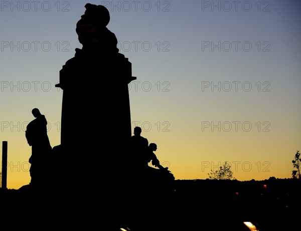 Majestic silhouette of a statue in prague, czech republic, standing tall against the backdrop of a vibrant sunset sky