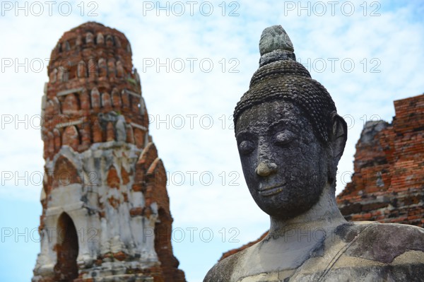 Serene buddha statue stands tall amidst ancient temple ruins, capturing the spiritual essence of ayutthaya's historical heritage