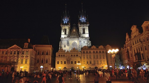 Tourists walking and enjoying old town square and church of our lady before tyn in prague at night