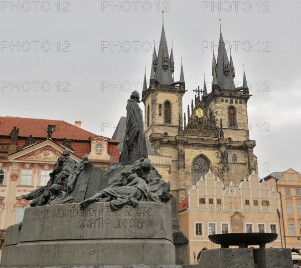 Jan hus monument standing tall in old town square, with the iconic tyn church rising majestically in the background, capturing the historical essence of prague