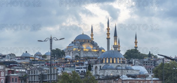 Majestic suleymaniye mosque glowing under cloudy sky at dusk, showcasing istanbul's rich history and architectural beauty
