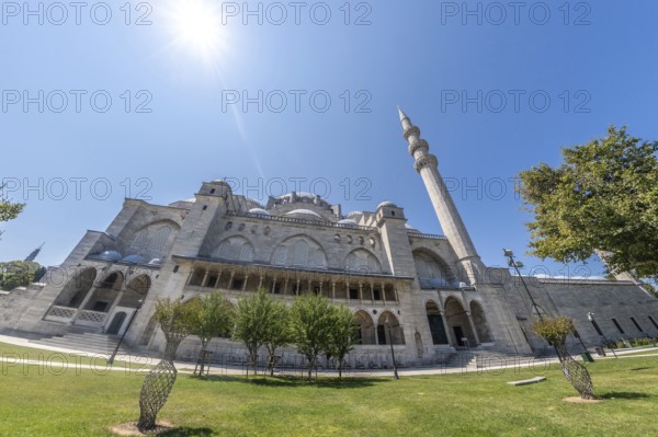 Suleymaniye mosque, a masterpiece of ottoman architecture, basks in the sunlight, showcasing its grandeur against the clear blue sky of istanbul