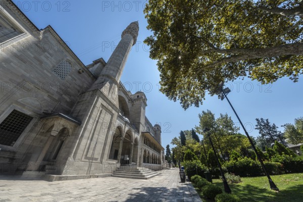 The historic semsi pasha mosque in istanbul, turkey, stands tall against a vibrant blue sky, its minaret reaching towards the heavens, surrounded by lush greenery