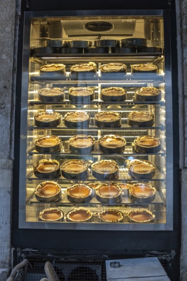 Rows of traditional turkish cheesecakes, called san sebastian cheesecakes, are displayed in a bakery window in istanbul, tempting passersby with their golden crusts