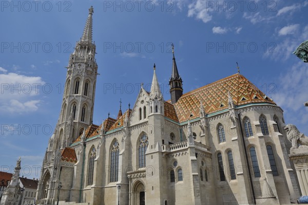 Matthias church with its colorful roof tiles and tall bell tower standing tall against a blue sky in budapest, hungary