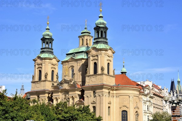 St. Nicholas church with its baroque architecture towers over the prague cityscape on a sunny day