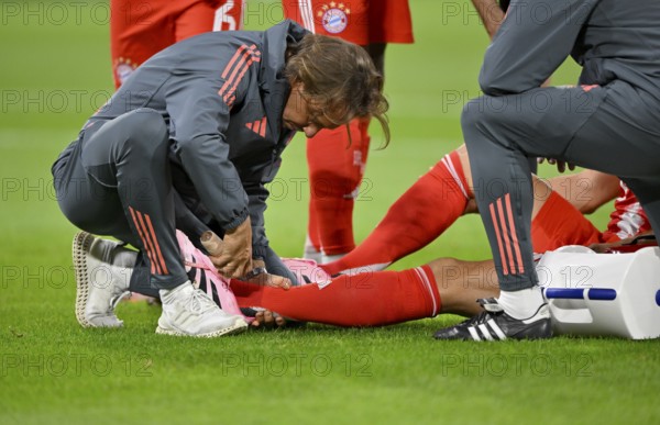 Club doctor Prof Dr Peter Ueblacker treats Leon Goretzka FC Bayern Muenchen FCB (08) injured Injury on the ground, ice spray, ankle, Allianz Arena, Munich, Bavaria, Germany