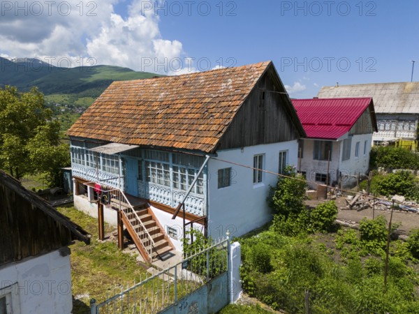 Traditional wooden house in a rural village with surrounding gardens and mountains in the background, aerial view, Lermontovo, inhabited by spiritual Christians Pryguny and Molokans from Russia, Lorikeet Province, Armenia