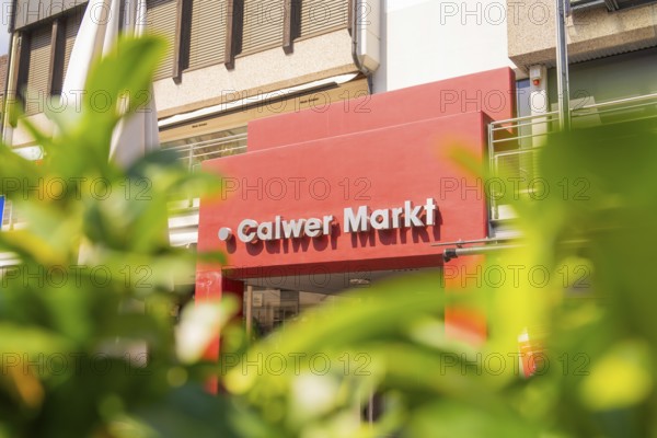 Calw market entrance with red facade, surrounded by plants on a sunny day, small town pearl Calw, Black Forest, Germany