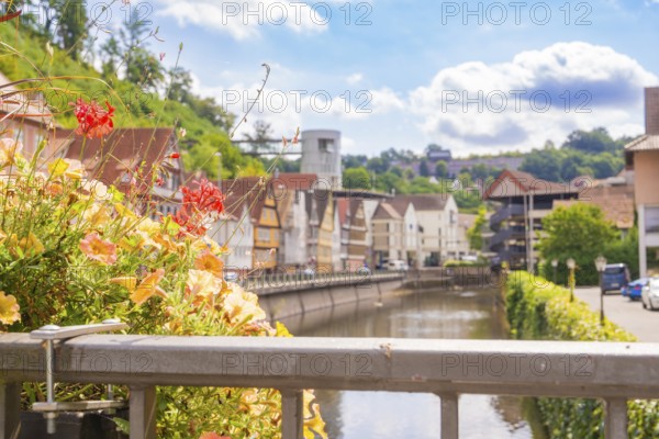 View over the river to a mixture of old and modern architecture in summery surroundings, small town pearl Calw, Black Forest, Germany