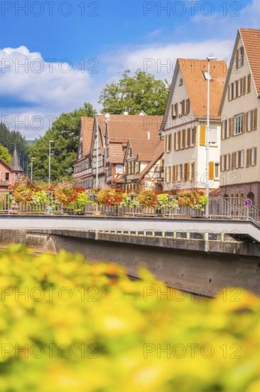 Summer city panorama with river, half-timbered houses and bridge under blue sky, small town pearl Calw, Black Forest, Germany