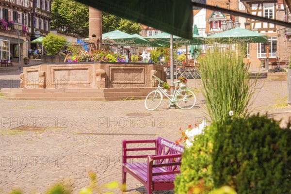 A lively square with a decorated bicycle and blooming fountain, small town pearl Calw, Black Forest, Germany