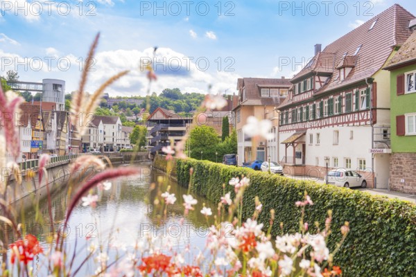 Idyllic river view with half-timbered houses and flowers in a summery atmosphere, small town pearl Calw, Black Forest, Germany