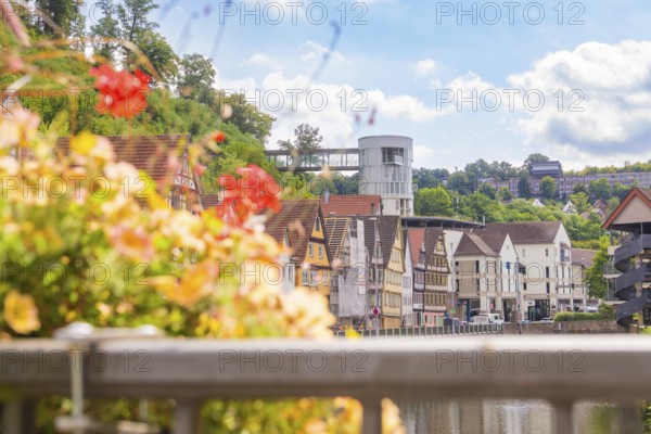 View of a cityscape by the river with colourful historic buildings and flowers, small town of Perle Calw, Black Forest, Germany