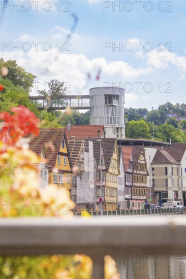 River view with traditional houses and modern architecture under a blue sky, small town of Perle Calw, Black Forest, Germany