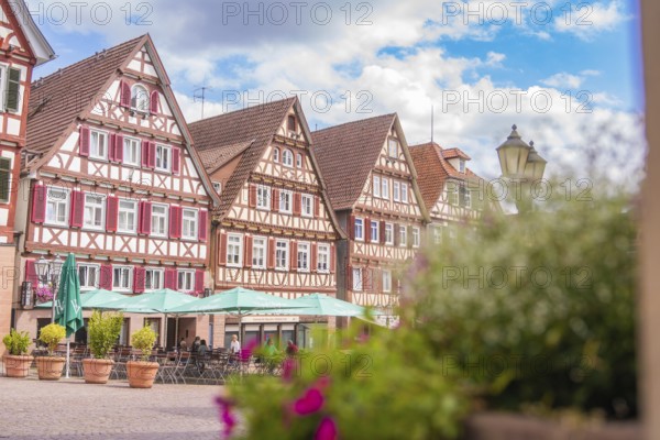 Beautiful street scene with half-timbered houses under a partly cloudy blue sky, small town Perle Calw, Black Forest, Germany