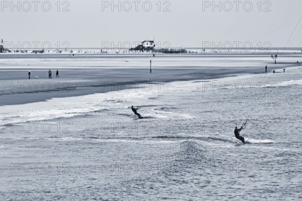 Two kitesurfers in the evening, monochrome, Sankt Peter-Ording, Eiderstedt peninsula, Wadden Sea National Park, North Sea, North Frisia, Schleswig-Holstein, Germany