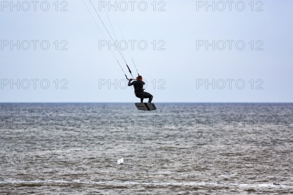 Kitesurfer jumping, Sankt Peter-Ording, Eiderstedt peninsula, Wadden Sea National Park, North Sea, North Frisia, Schleswig-Holstein, Germany