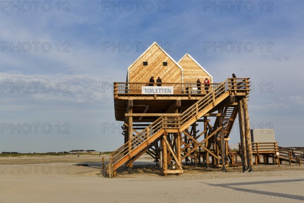 Pile dwelling, toilet house on the beach, walker, Sankt Peter-Ording, Eiderstedt peninsula, Wadden Sea National Park, North Sea, North Frisia, Schleswig-Holstein, Germany