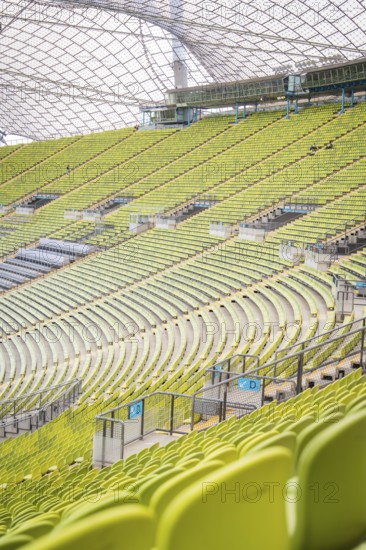 Detailed view of green rows of seats in a modern stadium with glass roof structure, Olympic Park, Munich, Germany