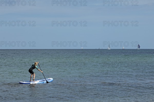 Girl stand-up paddling, Strande, Schleswig-Holstein, Germany