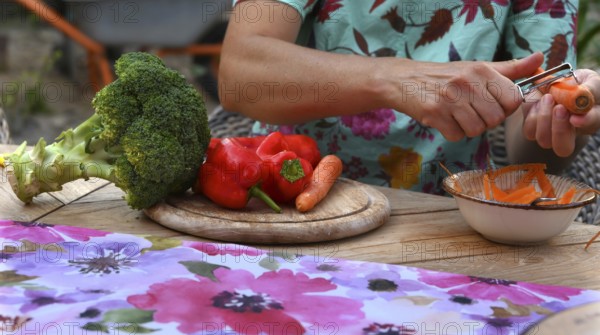 Various vegetables being prepared for a meal, carrots being peeled, Bavaria, Germany