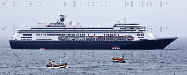 Cruise ship at sea with several small excursion boats for whale watching, Husavik, Iceland