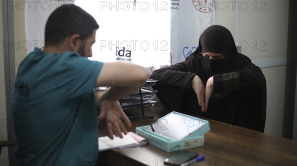 A doctor examining a woman inside a mobile medical point dedicated to treating Syrian refugees. Aleppo, Syria May 28, 2022, Aleppo, Syria