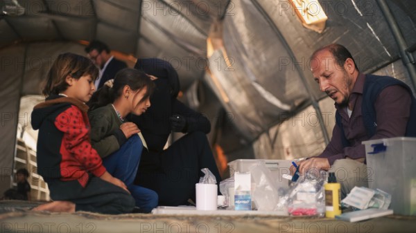A doctor examining a displaced Syrian child inside a mobile clinic at a refugee camp. Aleppo, Syria October 29, 2022, Aleppo, Syria