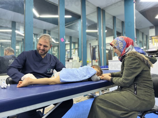 A displaced Syrian child receiving physical therapy from a physiotherapist after a war injury. Aleppo, Syria October 29, 2022, Aleppo, Syria