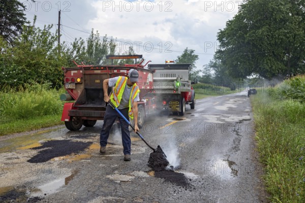 Glendora, Michigan - A worker for the Berrien County Road Department patches potholes on Wagner Road