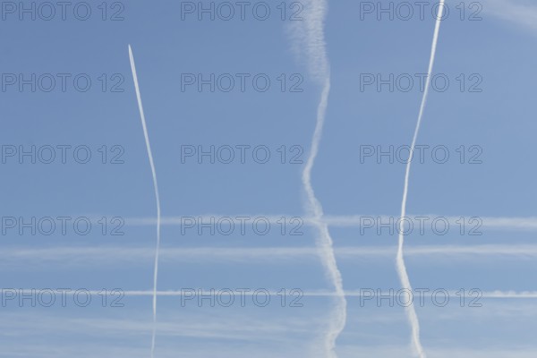 Jet aircraft vapour trails or contrails in a blue sky, England, United Kingdom