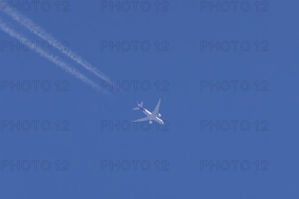 Airbus A300-600RF jet aircraft of FedEx Express airlines in flight with vapour trails or contrails behind in a blue sky, England, United Kingdom