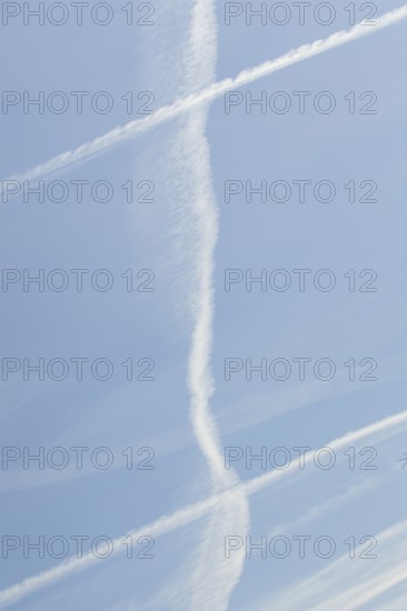 Jet aircraft vapour trails or contrails in a blue sky, England, United Kingdom