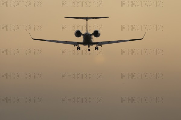Executive business jet passenger aircraft landing at sunset, London Stansted airport, Essex, England, United Kingdom