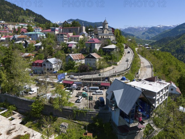 Winding road through a mountain town with a church and traditional architecture, clear view of the mountains, aerial view, Khulo, Chulo, Autonomous Republic of Adjara, Adjara, Lesser Caucasus, Georgia