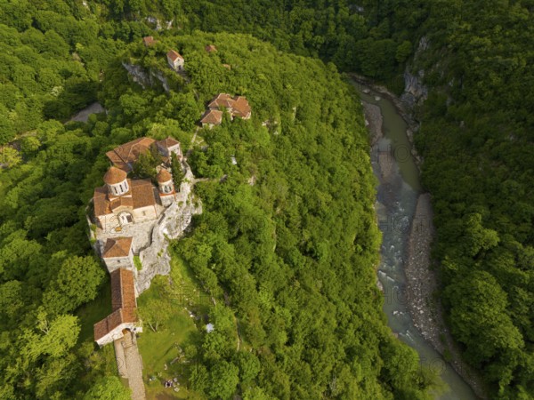 Aerial view of a monastery on a river, embedded in lush nature, aerial view, Motsameta Monastery, near Kutaisi, Zkalzitela River, Imeretia region, Georgia