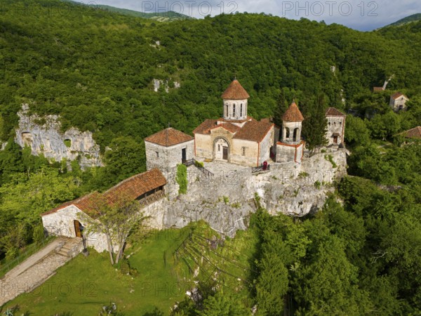Historic monastery on steep hills surrounded by lush greenery, aerial view, Motsameta Monastery, near Kutaisi, Imereti region, Georgia