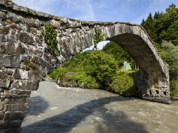 Old stone arch bridge over a river, surrounded by lush nature and clear sky, aerial view, Dandalo stone arch bridge, Adjaristskali River, Adjara Autonomous Republic, Adjara, Adjara, Lesser Caucasus, Georgia