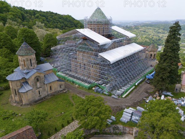 Large church with scaffolding on a hill in a green landscape, aerial view, Gelati Monastery near Kutaisi, UNESCO World Heritage Site, Imereti Region, Georgia