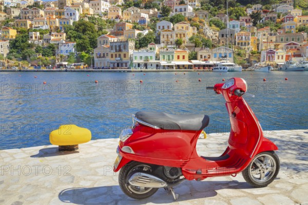 Red vespa scooter parked at Gialos harbour, Gialos, Symi Island, Dodecanese Islands, Greece