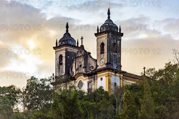 Baroque church behind the vegetation in the hills of the city of Ouro Preto